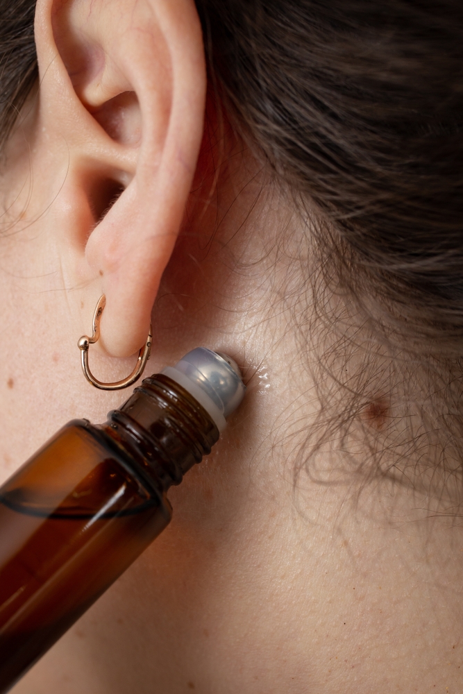 applying roll-on oil behind ear for holistic growth- U R Royalty - Cypress, Texas